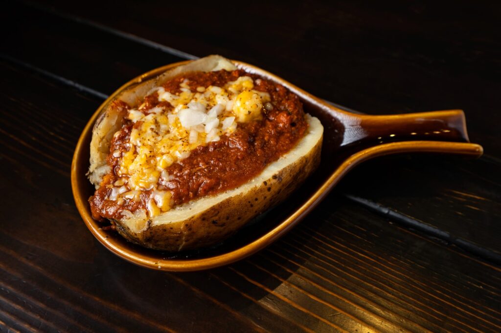 Baked potato loaded with chili, cheese and onion