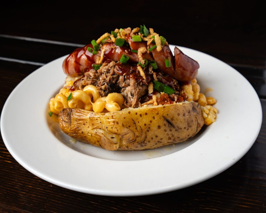 Baked potato loaded with smoked sausage, pulled pork and mac and cheese