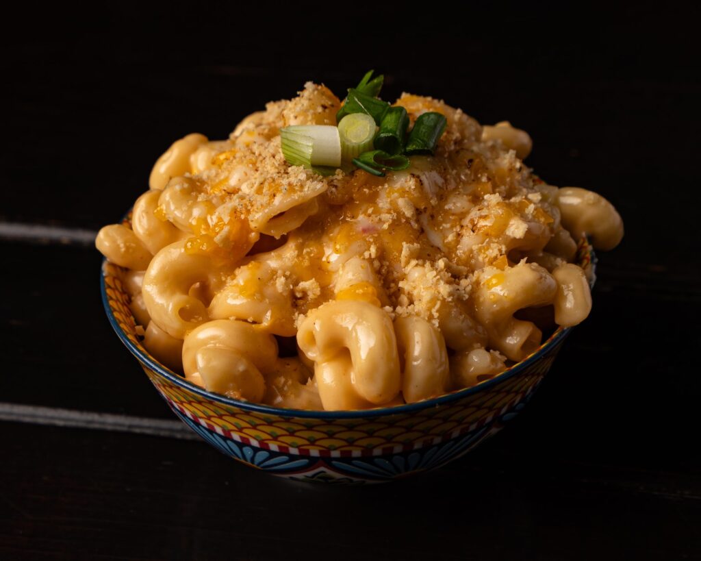 Bowl of smoked mac and cheese topped with breadcrumbs and green onion