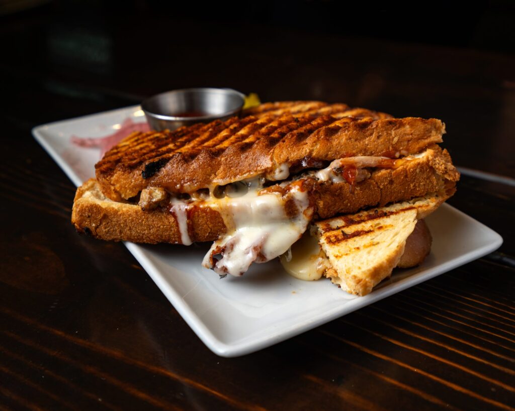 Brisket melt panini with melted cheese, pickles and pickled onion