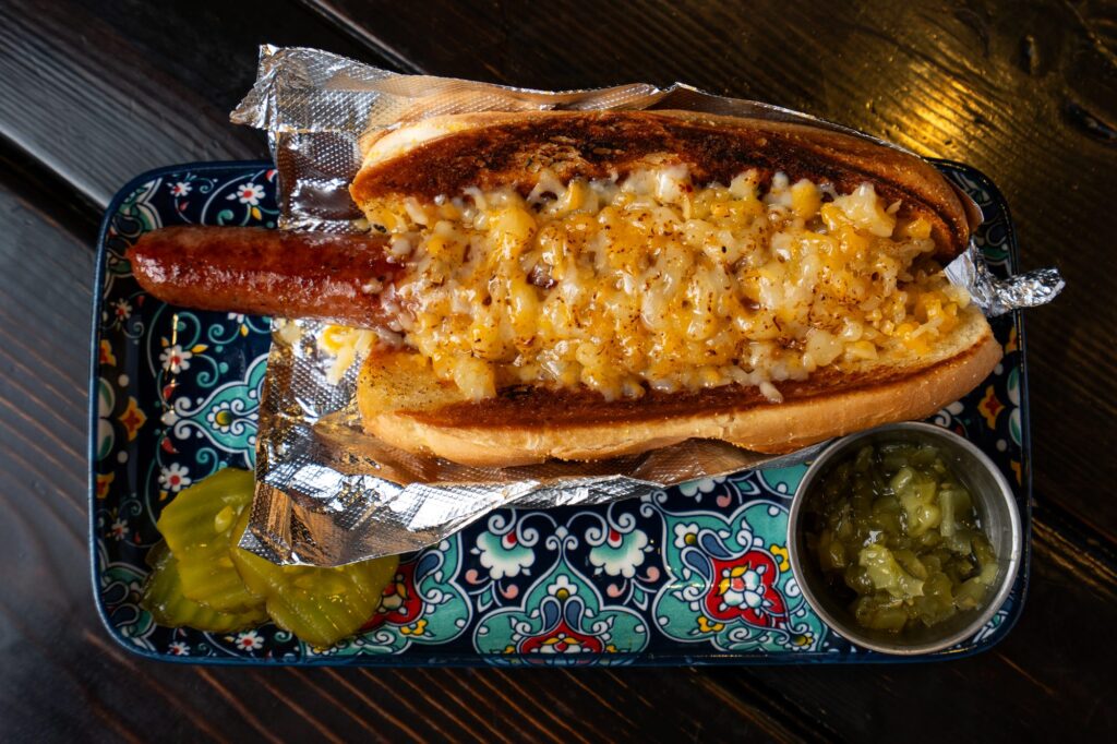 Chili dog topped with cheese and diced onion