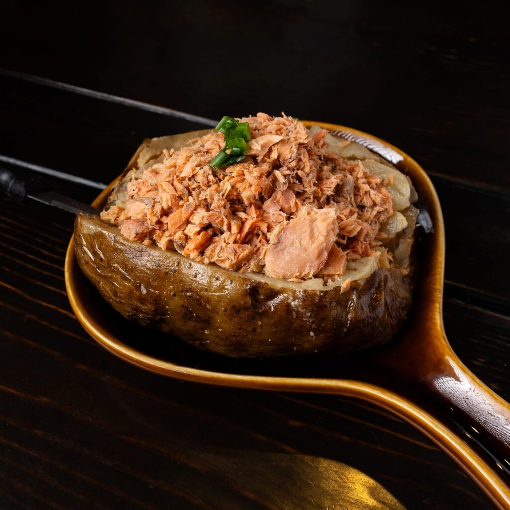 Flaked smoked salmon on a loaded baked potato