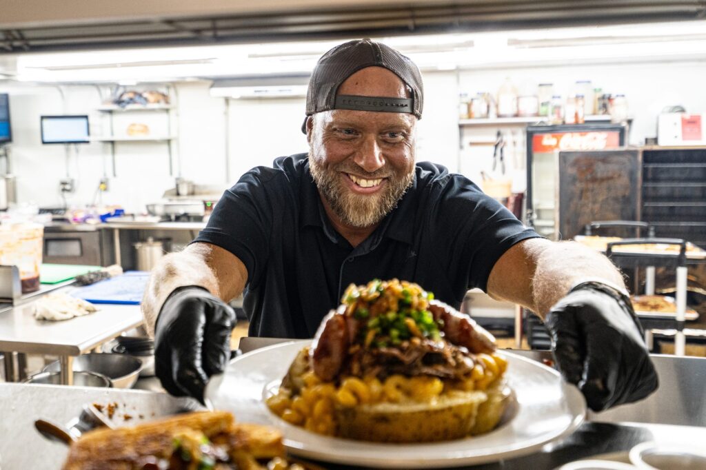 Frank presenting a loaded baked potato from the smokehouse kitchen
