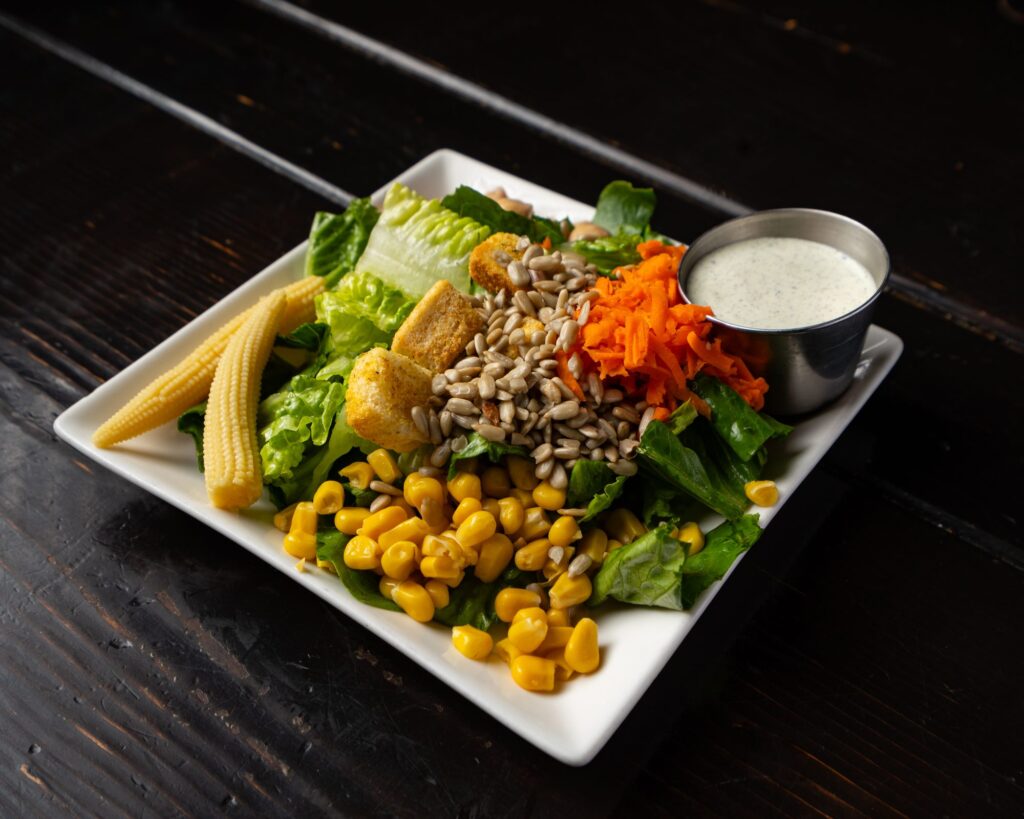 Garden salad with corn, shredded carrot, sunflower seeds and ranch