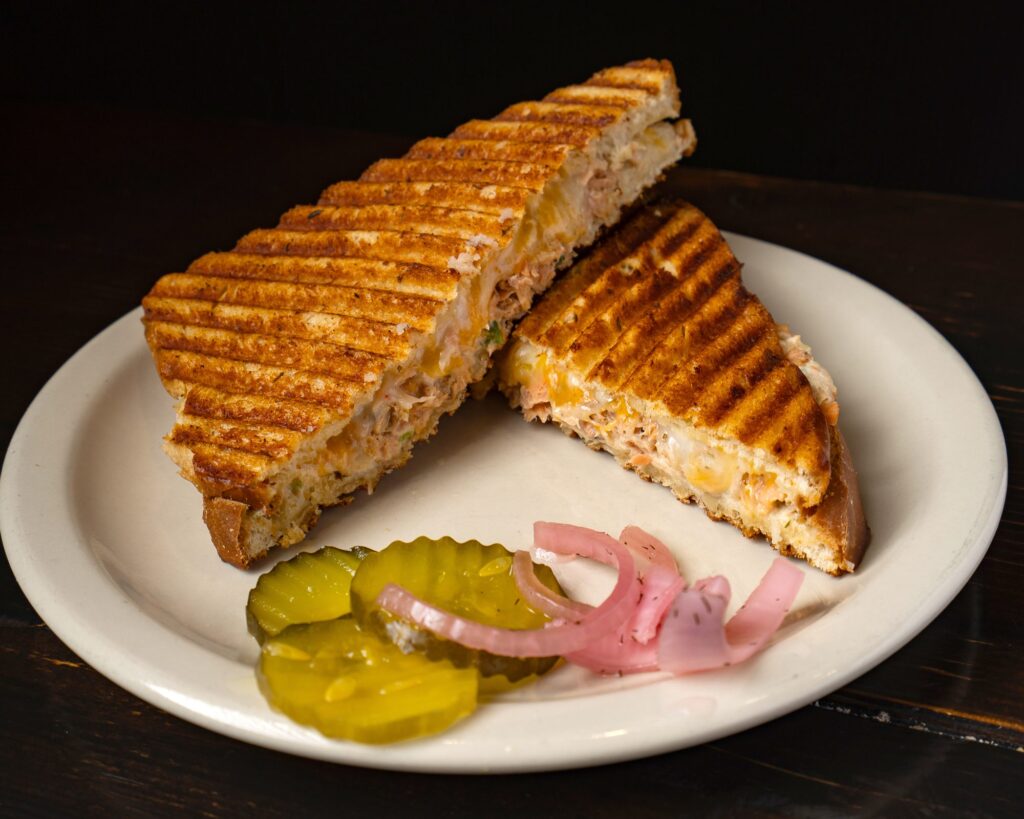 Grilled panini halves with pickles and pickled red onion