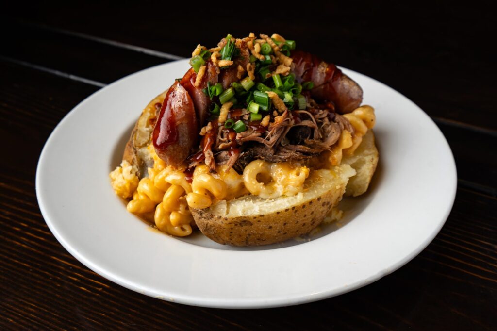 Loaded baked potato with pulled pork, smoked sausage and mac and cheese