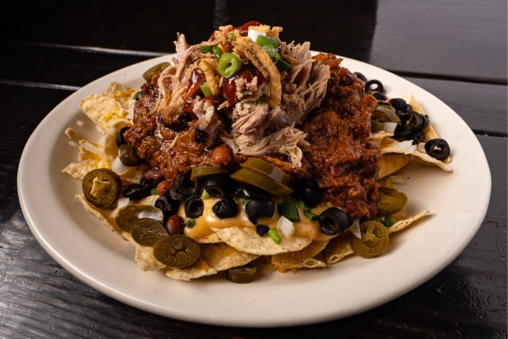 Pulled pork nachos with black olives, jalapenos and cheese