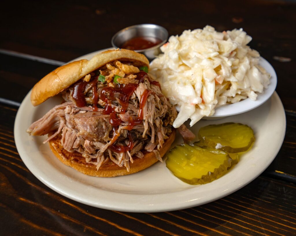 Pulled pork sandwich with BBQ sauce, coleslaw and pickles